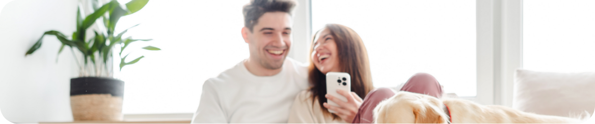 Pareja feliz con su perro en casa, disfrutando la tranquilidad de contar con un seguro de hogar confiable en CDMX y Querétaro